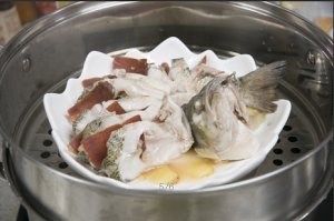 將鱸魚成花狀擺好，將火腿切片放入各縫隙中，放入鍋中隔水蒸12分鐘拿出，撒上蔥花即可。