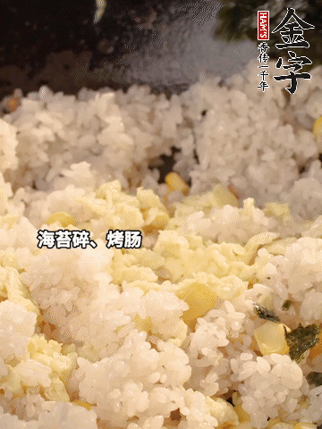 剩米飯下鍋炒散，依次下玉米粒、雞蛋、烤腸、海苔碎翻炒均勻。