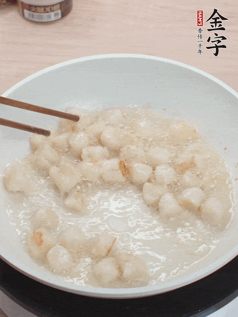 油溫4成熱，鮮貝蘸干淀粉下鍋煎，一面微黃后翻面。