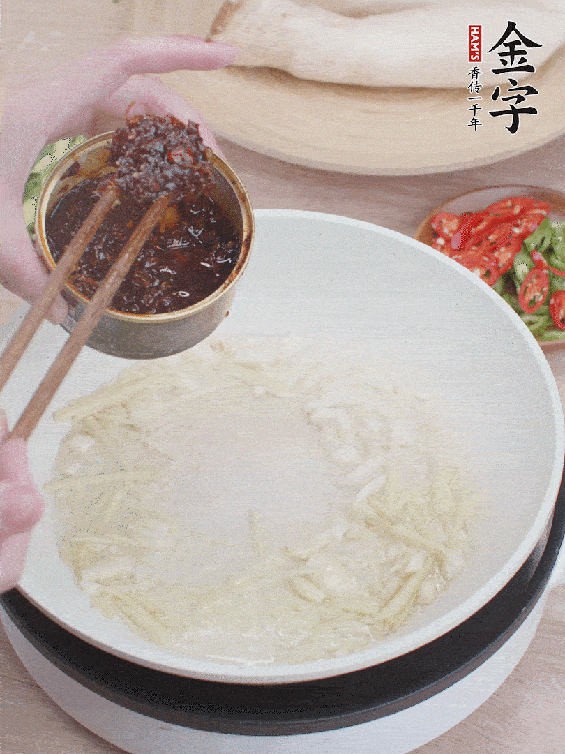 起鍋熱油，姜蒜、金字火腿干貝醬煸香。