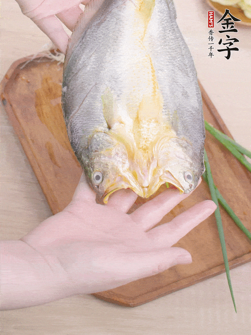 黃魚背部開(kāi)刀，洗凈切花刀。適量鹽涂抹魚身兩面。