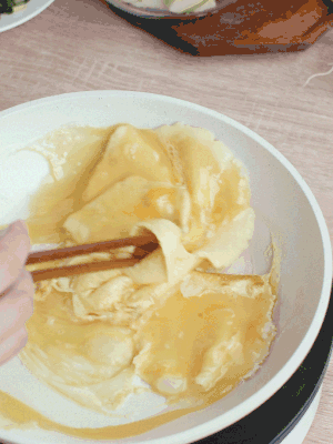 油6成熱時，下雞蛋液，邊緣凝固時翻拌成塊狀。