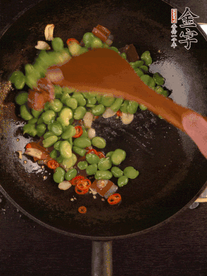 再下蠶豆煸炒，加1勺料酒調(diào)味。