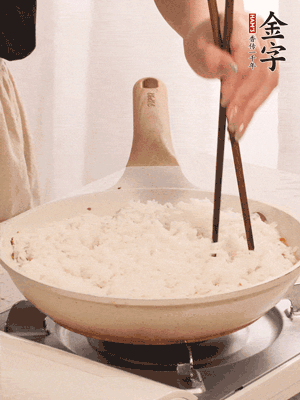 把瀝干水分的米飯均勻鋪在上面，筷子戳幾個(gè)洞，以便透氣，轉(zhuǎn)小火蓋上蓋子燜至水分收干，大概10分鐘。